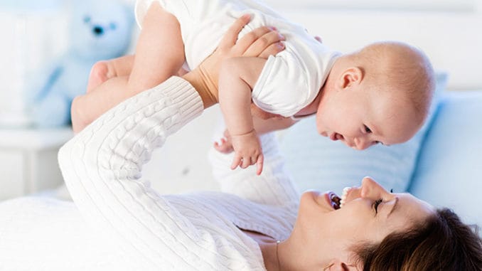 Šťastná maminka telepaticky komunikuje s mozkem dítěte.